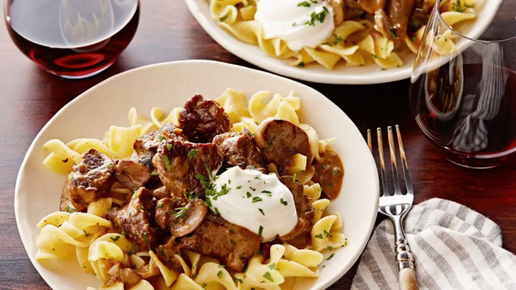 plated Beef Stroganoff with Buttered Noodles topped with parsley