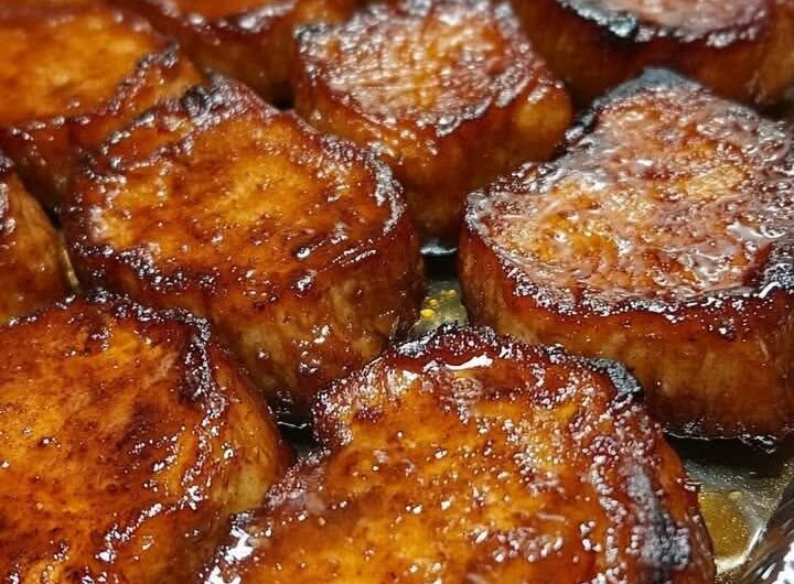 candied sweet potatoes baked in a dish with glossy caramelized sauce