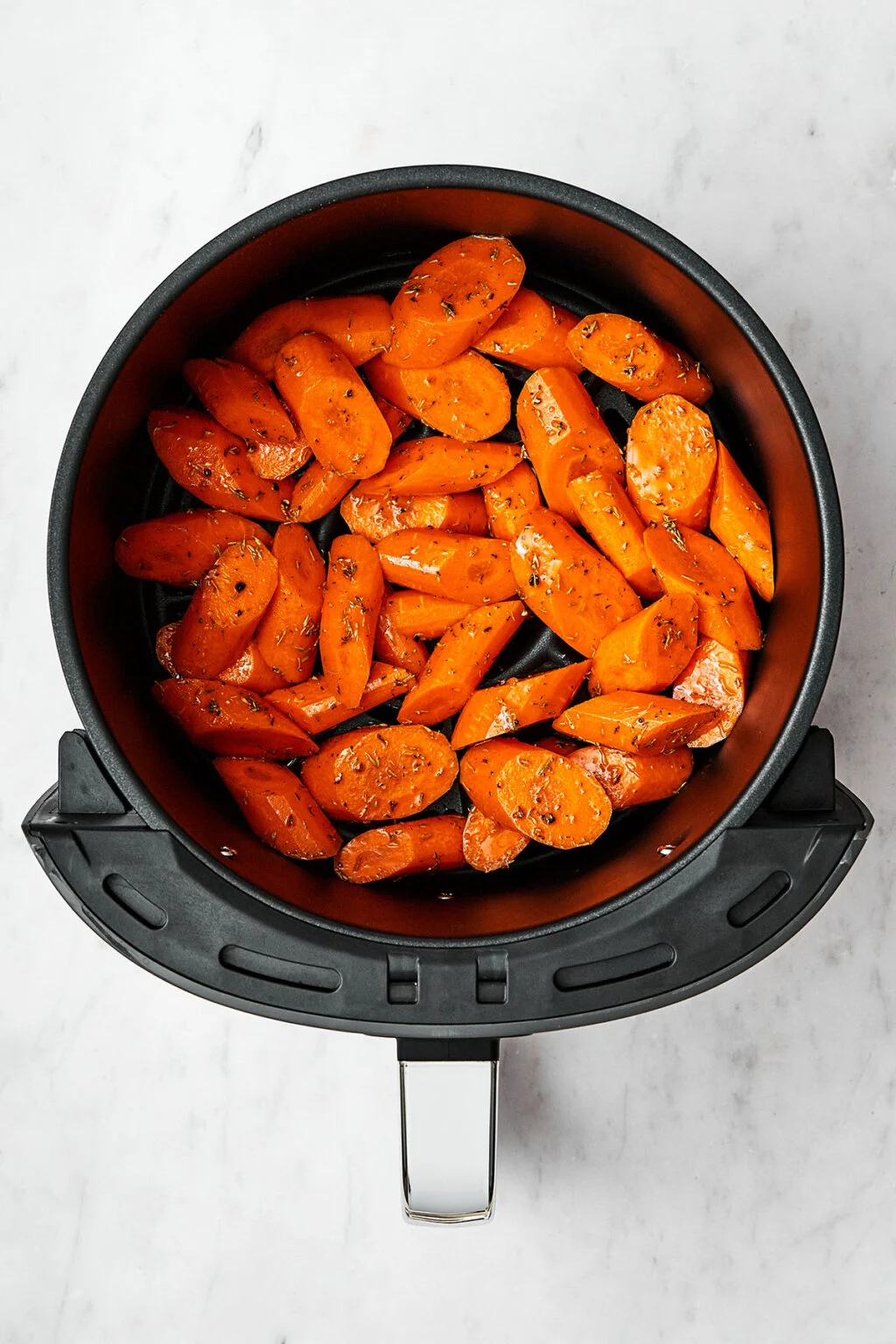 Carrots tossed in oil and seasoning for Air Fryer Roasted Carrots