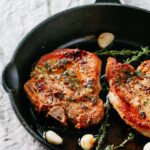 juicy garlic herb baked pork chops in a pan