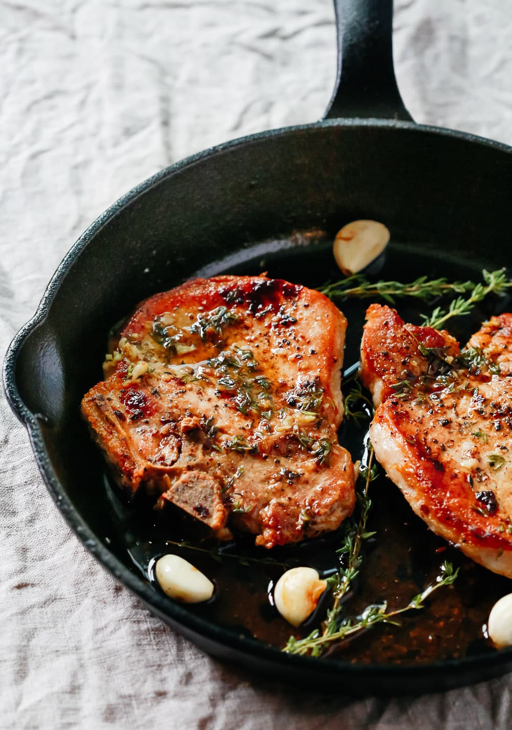 juicy garlic herb baked pork chops in a pan