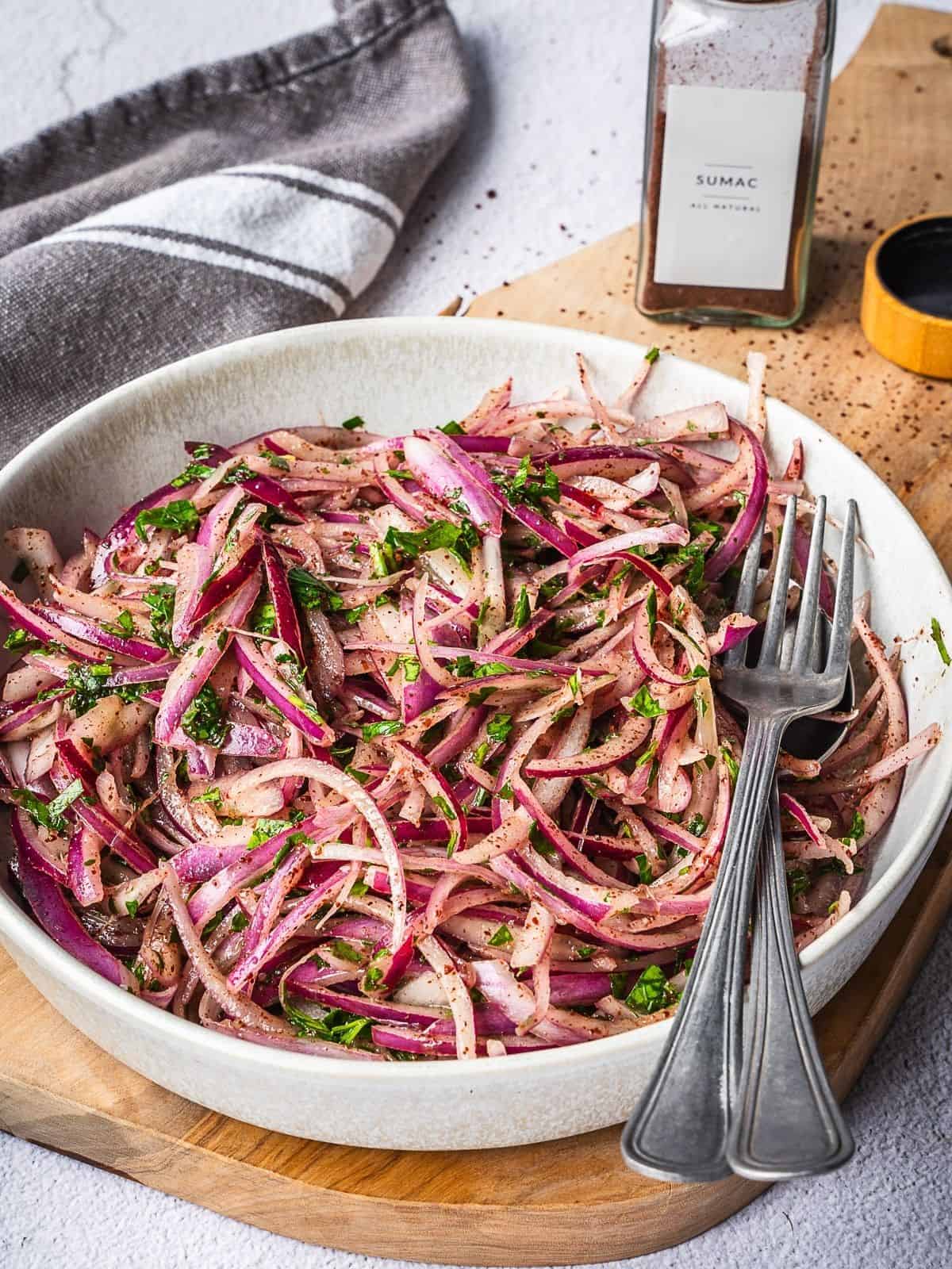 Thinly sliced onions in a bowl ready to be turned into sumac onions